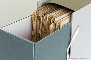 Ein geöffneter Archivkarton mit Papieren
