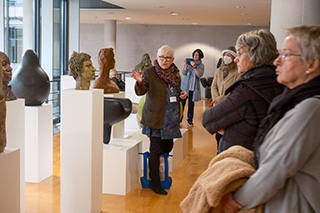 Besuchergruppe vor einem Kunstwerk, eine Gästeführerin erläutert die Kunst am Bau in der Deutschen Nationalbibliothek in Frankfurt am Main.